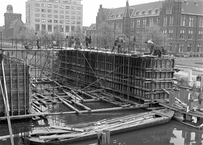 Het storten van de middenpijler van de eerste St. Sebastiaansbrug. Rechts het voormalige laboratorium van de Afdeling Physica en Electrotechniek van de Polytechnische School.