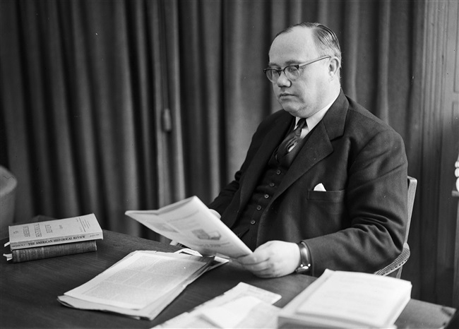 Gedeputeerde Harm van Riel leest in zijn werkkamer, 1958