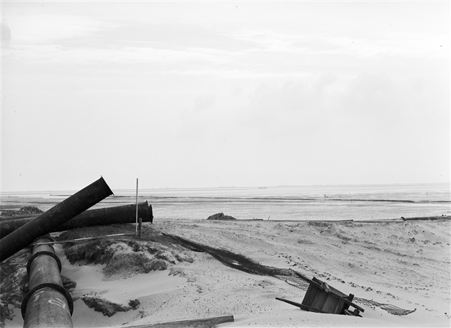 De dijk bij Oude-Tonge wordt hersteld na de watersnoodramp van 1 februari 1953. Zand en water worden via een buis geperst naar de plek waar een nieuw dijklichaam wordt opgespoten.