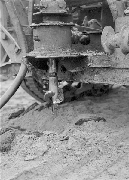 Aanleg van een weg op zandpalen. Een boormachine boort gaten die met grindzand worden opgevuld. Deze fundering van zandpalen voorkomt dat de weg verzakt.