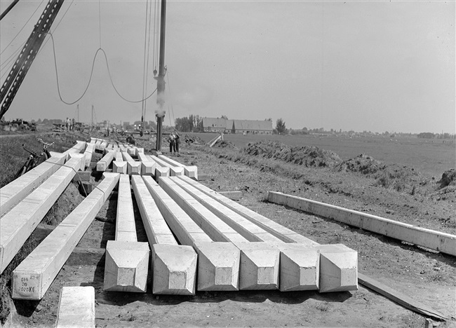 Een heipaal wordt de grond ingeslagen bij de aanleg van de weg op palen tussen Boskoop en Alphen aan den Rijn. De palen zijn ongeveer 13 meter lang en wegen 2475 kilo.