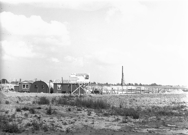 Aanleg recreatiegebied. Op het bord staat de tekst: 'Hier komt Schoonhovens recreatie oord. Zwembad, jachthaven, camping.'