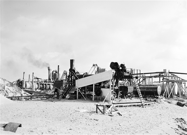 Dijkherstel op Goeree-Overflakkee, na de watersnoodramp van 1 februari 1953. In de polder Galathee (Ooltgensplaat) is een asfaltfabriek gebouwd. Met het geproduceerde asfalt worden de herstelde dijken aan de zeezijde bekleed.