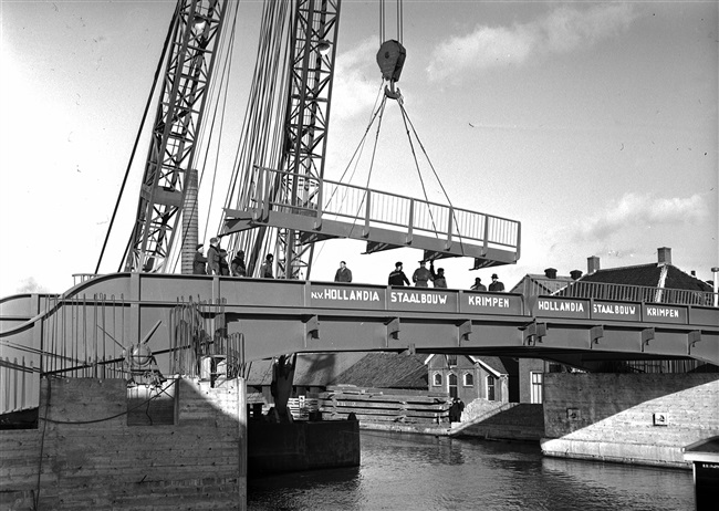 Een drijvende bok plaatst het hekwerk van de 's-Molenaarsbrug.