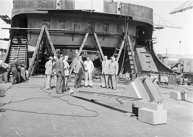 Gedeputeerde A.C.A. Deerenberg (rechts) bezichtigt de veerboot Haringvliet, die een volledige nieuwe opbouw krijgt.