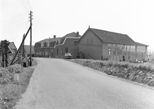 Een verhoogde dijk met woningen, waarvan er enkele gevijzeld zullen worden, oftewel omhoog gebracht.