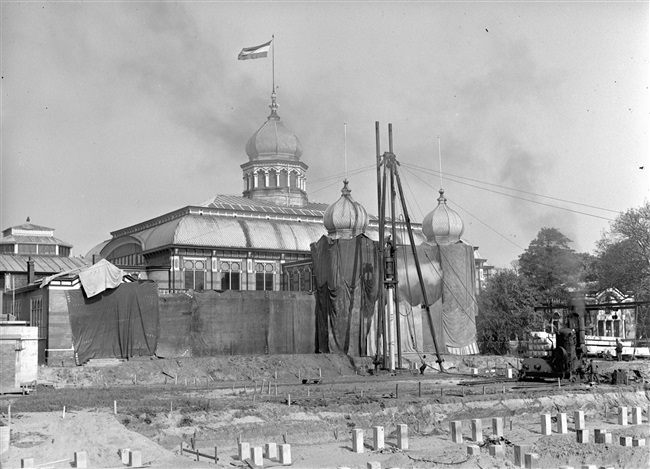 Heiwerkzaamheden voor de laagbouw van het nieuwe provinciehuis. Op de achtergrond het Moorse Paleis (hoofdgebouw) van de voormalige Haagsche Dierentuin.