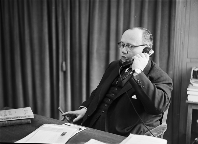 Gedeputeerde Van Riel telefoneert in zijn werkkamer, 1958