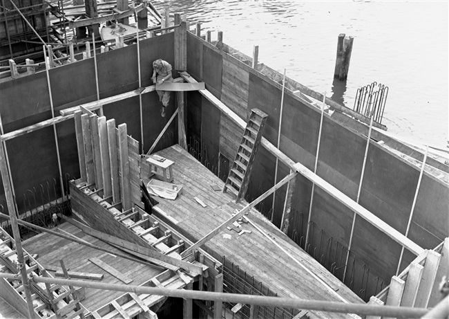 Een betontimmerman werkt aan de bekisting van de middenpijler en het landhoofd van de eerste St. Sebastiaansbrug.