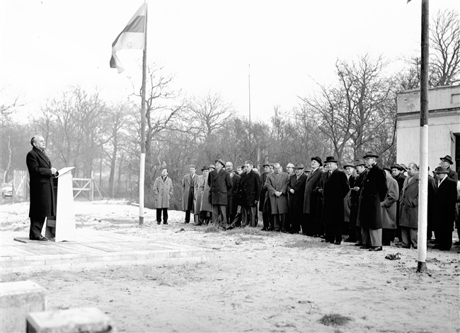 Bouw van het provinciehuis aan de Koningskade. Jan Klaasesz, commissaris van de Koningin, houdt een toespraak als het hoogste punt van het gebouw is bereikt.