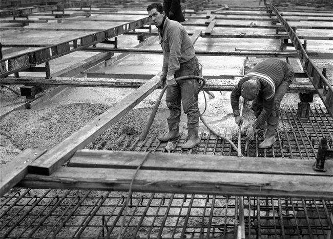 Een betonstorter stort beton in de bekisting voor het zuidelijke viaduct. Het viaduct is onderdeel van de eerste St. Sebastiaansbrug.