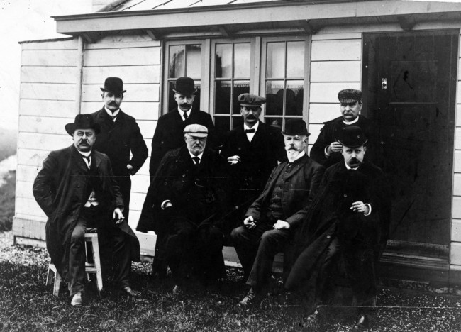 Ir. J.M.W. van Elzelingen (derde van links staand met pet) temidden van het college van Gedeputeerde Staten van Zuid-Holland. Van Elzelingen was hoofdingenieur bij de Provinciale Waterstaat van 1908 tot 1927. De foto is rond 1915 genomen bij het directieverblijf 'De Keet' in Nieuwveen.