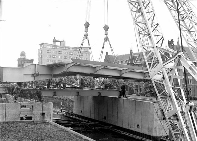 De bovenbouw van de eerste St. Sebastiaansbrug wordt geplaatst. Rechts op de achtergrond het voormalige laboratorium van de Afdeling Physica en Electrotechniek van de Polytechnische School.