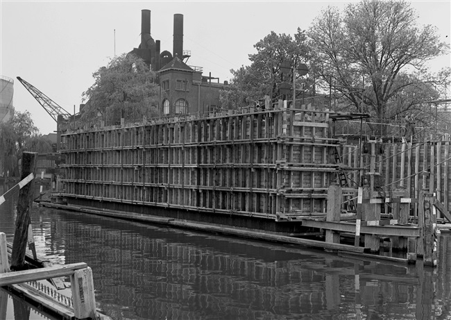 Bekisting van de middenpijler van de eerste St. Sebastiaansbrug, over het Rijn-Schiekanaal. De basculebrug verbindt de oude binnenstad van Delft met de TU-wijk. Op de achtergrond de gasfabriek, die later is gesloopt.