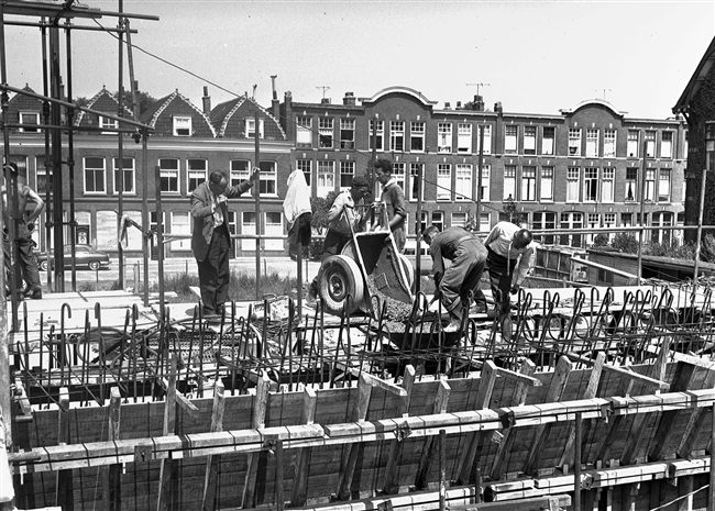 Betontimmermannen storten beton in de bekisting, voor de kelderwand van de eerste St. Sebastiaansbrug.