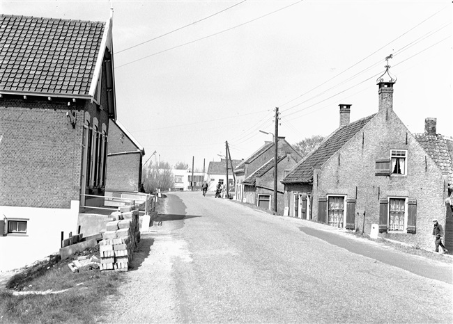 Een verhoogde dijk met woningen, waarvan er enkele gevijzeld zullen worden, oftewel omhoog gebracht.