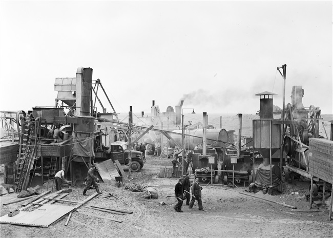 Dijkherstel op Goeree-Overflakkee, na de watersnoodramp van 1 februari 1953. In de polder Galathee (Ooltgensplaat) is een asfaltfabriek gebouwd. Met het geproduceerde asfalt worden de herstelde dijken aan de zeezijde bekleed.