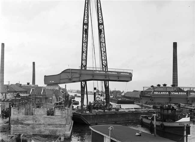 Een drijvende bok plaatst de bovenbouw van de 's-Molenaarsbrug op het brughoofd.