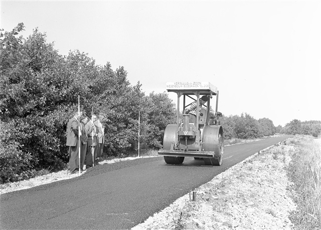 Een walsmachinist verdicht het asfalt met een wals, bij de aanleg van het fietspad nr. 18. Door het aanleggen van fietspaden ontsluit de provincie Zuid-Holland gebieden voor recreatie.