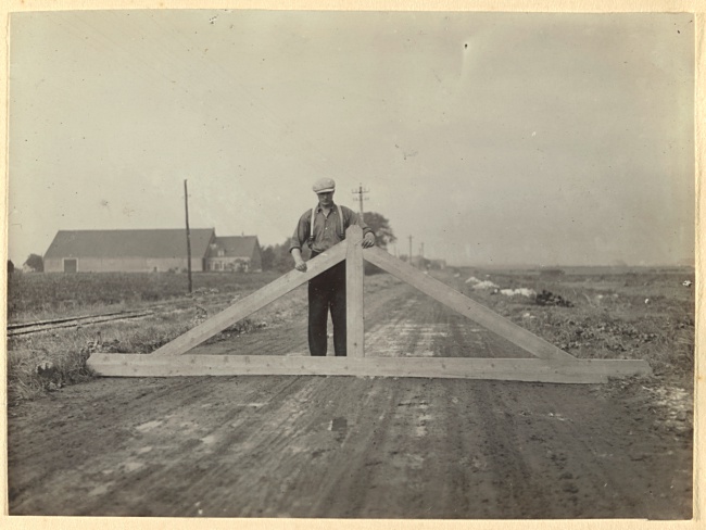 Werker meet of de wegfundering vlak ligt bij Brielle, 1929