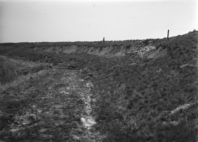 De beschadigde Zegenpoldersedijk is met zandzakken verstevigd, na een storm op 23 december 1954.