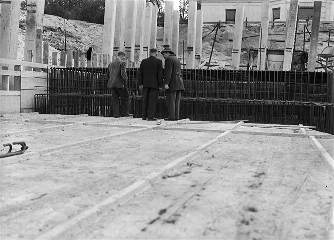 De betonfundering van het in aanbouw zijnde provinciehuis. Op de heipalen staat met streepjes aangegeven waar ze moeten worden weggehakt.