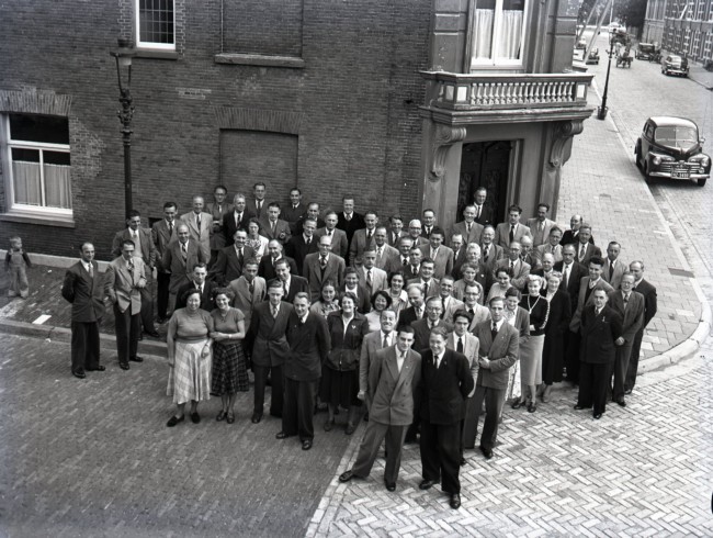 Ambtenaren staan bij het pand aan de Riouwstraat 172. De Provinciale Waterstaat gebruikte vanaf 1947 dit gebouw tijdelijk als kantoor. De foto is waarschijnlijk gemaakt tussen 1950 en 1952.