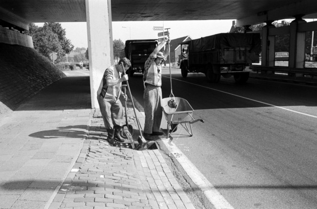 Wegwerkers maken een put langs de weg schoon, 1973