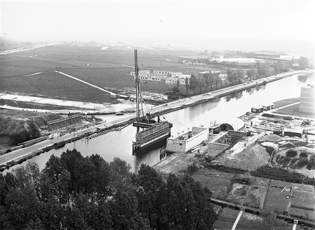 Bouw van de Zijlbrug, een basculebrug over de Zijl, aan de huidige Willem de Zwijgerlaan (rechts). Links op de achtergrond de aanleg van de Engelendaal en rechts de voormalige Verenigde Touwfabrieken aan de Zijldijk in Leiderdorp.