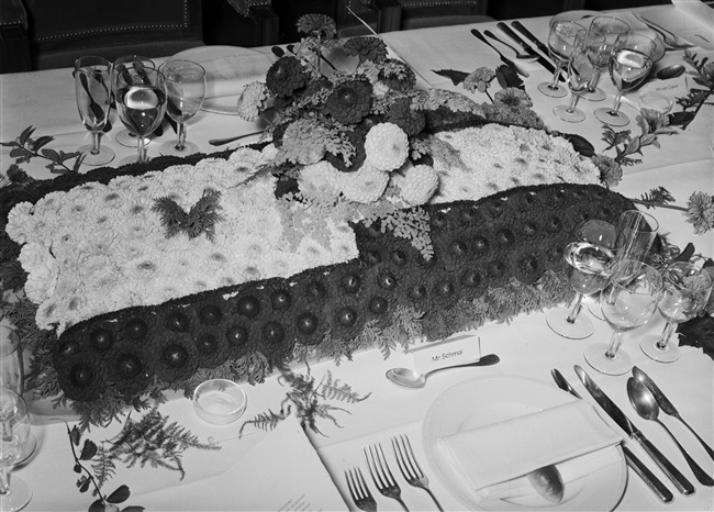 Een gedekte tafel met bloemstuk voor het afscheidsdiner van mr. L.A. Kesper, commissaris van de Koningin. Het diner vond plaats in het gebouw aan het Korte Voorhout 1.