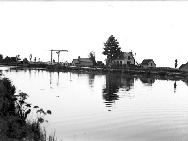 De oude Vijfgatenbrug bij de Westkanaalweg (N461) en het Aarkanaal. Het witte huis onder de boom is een voormalige brugwachterswoning. Deze foto is gemaakt tussen 1920 en 1940.
