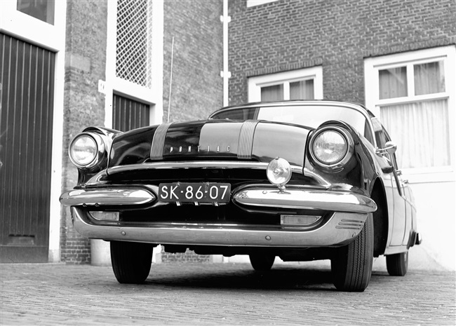 Een dienstauto van de provincie Zuid-Holland voor de garage aan de Schouwburgstraat. De foto van de Pontiac werd gebruikt in het verslag van de eerste provinciale Verkeersdag.