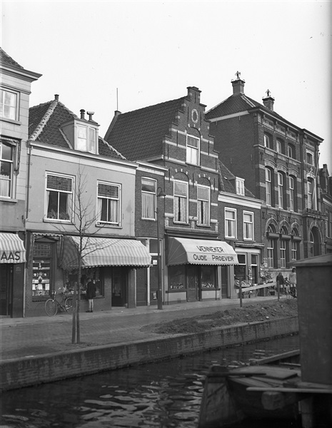 De Verwersdijk met Wenneker Oude Proever op nr. 14 en het kantoor van de Delftsche Courant op nr. 10. De foto is waarschijnlijk gemaakt tussen 1946 en 1952.