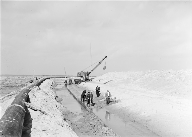 Dijkherstel in de polder Galathee (Ooltgensplaat), na de watersnoodramp van 1 februari 1953. Met behulp van o.a. een dragline wordt een nieuw dijklichaam gevormd.
