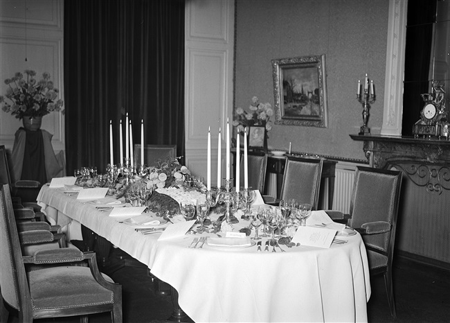 Een gedekte tafel voor het afscheidsdiner van mr. L.A. Kesper, commissaris van de Koningin. Het diner vond plaats in het gebouw aan het Korte Voorhout 1, waar het Provinciaal Bestuur van Zuid-Holland was gehuisvest.