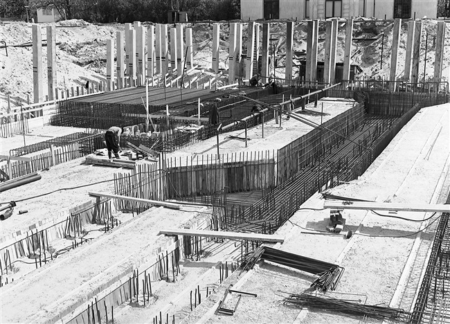 De betonfundering wordt gemaakt van het in aanbouw zijnde provinciehuis. Op de heipalen staat met streepjes aangegeven waar ze moeten worden weggehakt.