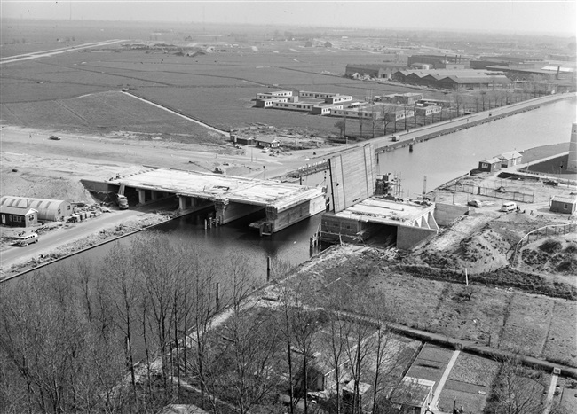 Bouw van de basculebrug Zijlbrug over de Zijl aan de huidige Willem de Zwijgerlaan (rechts). Links op de achtergrond de aanleg van de Engelendaal en rechts de voormalige Verenigde Touwfabrieken aan de Zijldijk in Leiderdorp.