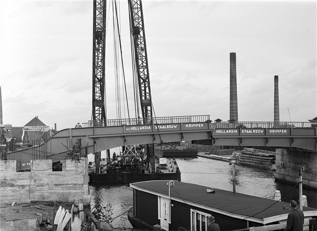 Een drijvende bok plaatst de bovenbouw van de 's-Molenaarsbrug op het brughoofd.