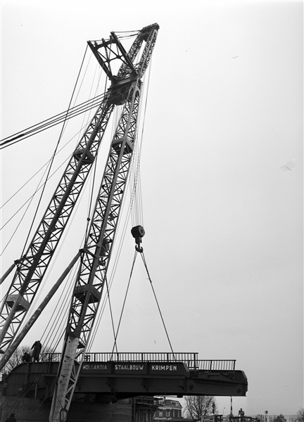 Een drijvende bok plaatst de bovenbouw van de 's-Molenaarsbrug op het brughoofd.