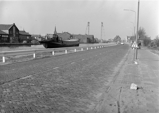 Bermbeveiliging langs Den Ham, provinciale weg nr. 25. Op de achtergrond de Hefbrug Boskoop over de Gouwe.