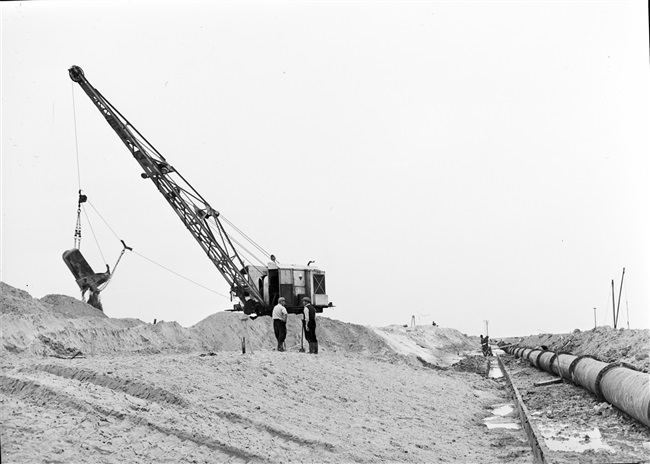 Dijkherstel bij Oude-Tonge na de watersnoodramp van 1 februari 1953. Met behulp van een dragline wordt een nieuw dijklichaam gevormd.