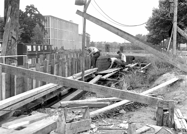 Betontimmermannen timmeren een bekisting van de eerste St. Sebastiaansbrug.